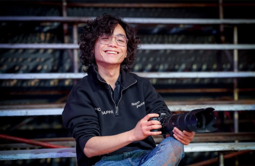 Nam Pesesse souriant, son appareil photo à la main