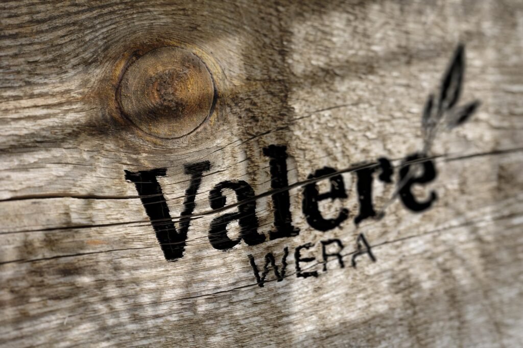 Présentation du logotype Valère Wera sur une matière bois
