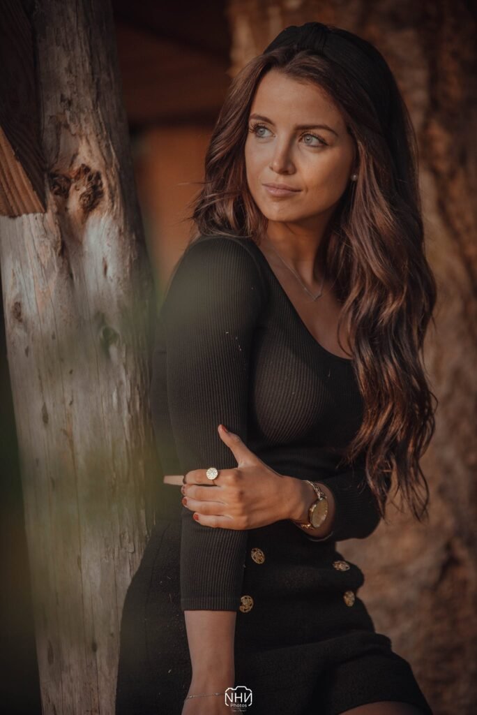 Portrait féminin en lumière naturelle près d’une poutre en bois