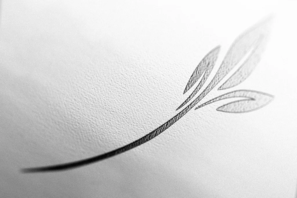 Détail en relief d’un symbole végétal gris sur papier blanc